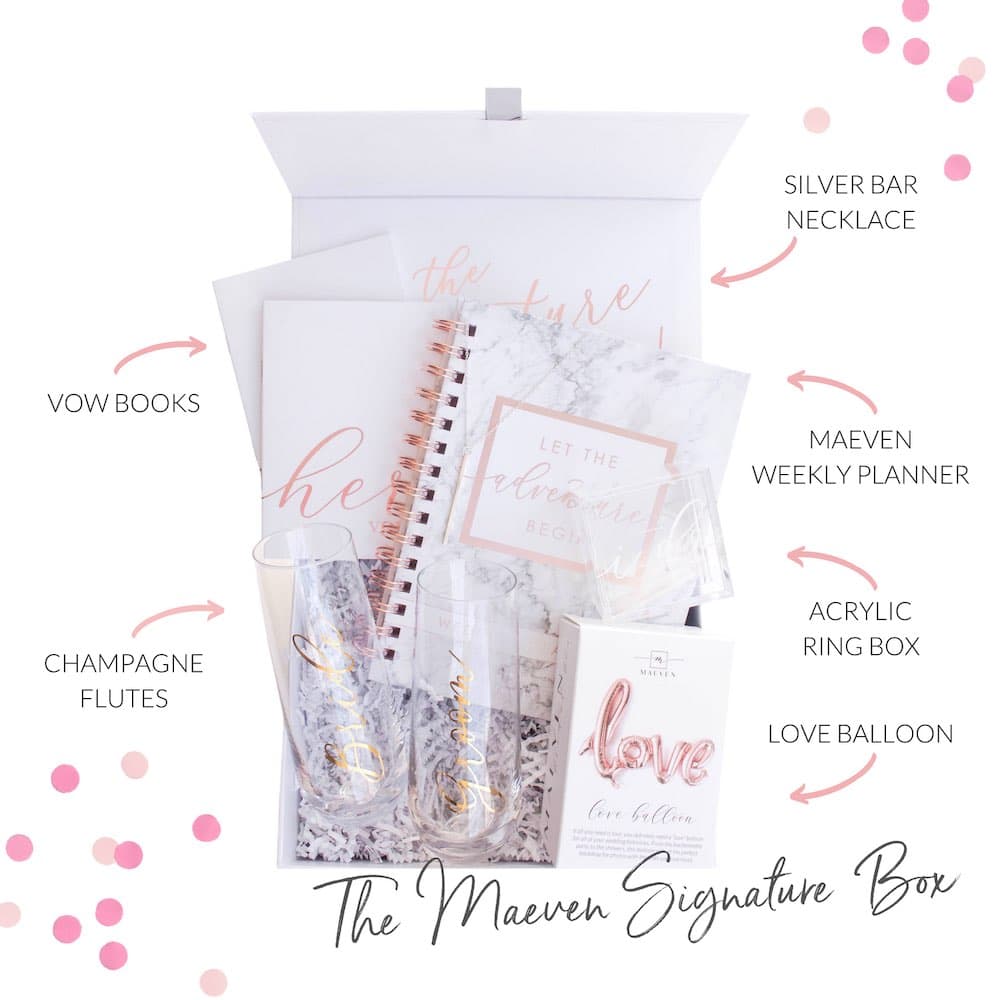 Here's a rephrased version of the alt text description for a similar photo:

Elegant wedding preparation kit featuring a personalized bridal planner, crystal champagne glasses, and a transparent ring display case, all arranged in a stylish gift box